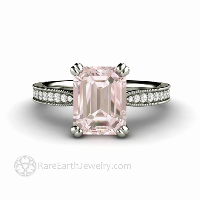 May include: A silver engagement ring with a pink emerald-cut gemstone and a diamond-encrusted band. RareEarthJewelry.com
