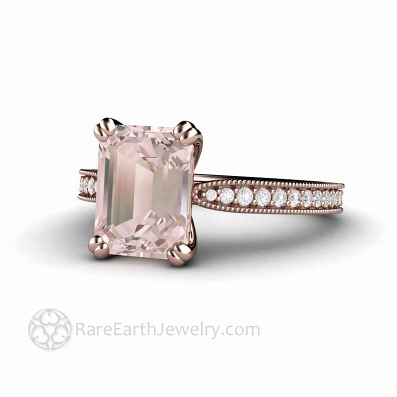 May include: A rose gold engagement ring with a large, pale pink, emerald-cut gemstone and a delicate band of smaller diamonds.