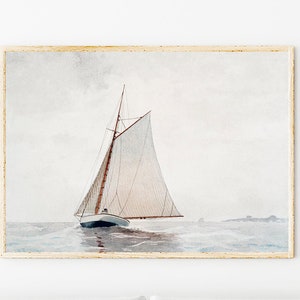 Puede incluir: Una pintura de acuarela de un velero con velas blancas en un mar tranquilo y gris. El velero navega lejos del espectador, con la proa del barco mirando hacia el lado izquierdo de la imagen. La pintura est&aacute; enmarcada en un marco de madera claro.
