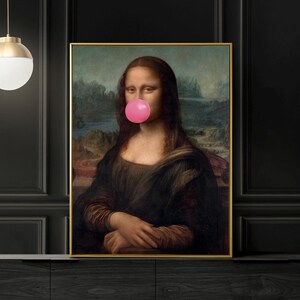 May include: A framed print of the Mona Lisa with a pink bubble gum stuck to her mouth. The print is hanging on a black wall above a dark wood cabinet.