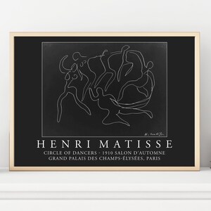 May include: Black and white line art print of Henri Matisse's "Circle of Dancers" artwork. The print features a single continuous line drawing of dancers in a circle. The print is framed in a light wood frame and has the title "Henri Matisse" and "Circle of Dancers - 1910 Salon d'Automne Grand Palais des Champs-&Eacute;lys&eacute;es, Paris" printed below the artwork.