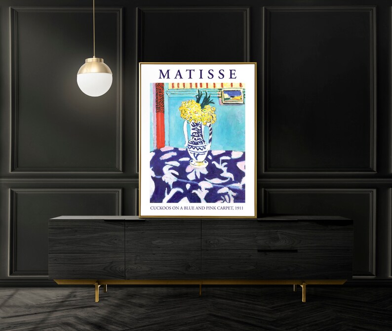 May include: A poster of a painting by Henri Matisse titled "Cuckoos on a Blue and Pink Carpet, 1911". The painting depicts a vase of yellow flowers on a blue and pink patterned tablecloth.