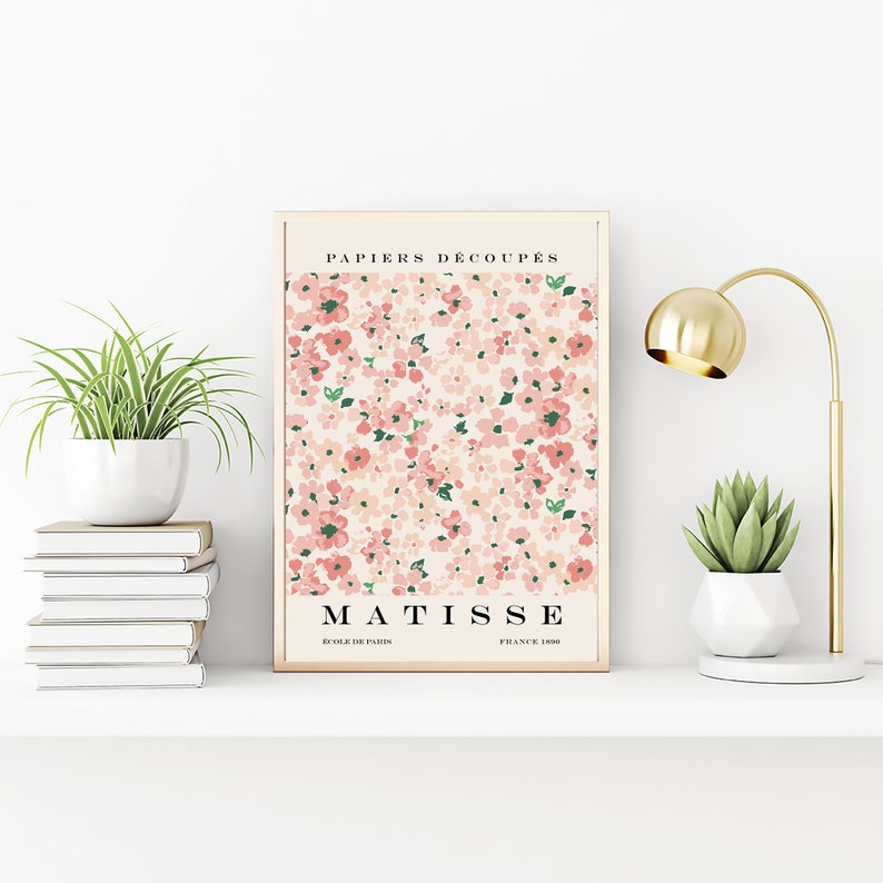 May include: A framed print with a pink and green floral pattern. The print has the text "PAPIERS DECOUPES" at the top and "MATISSE" at the bottom. The text "ECOLE DE PARIS" and "FRANCE 1950" are also included.