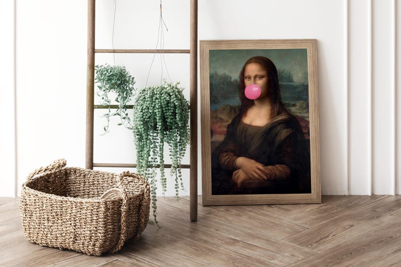 May include: A framed print of the Mona Lisa painting with a pink bubble gum stuck to her mouth. The print is hanging on a white wall next to a wooden ladder with two hanging plants.