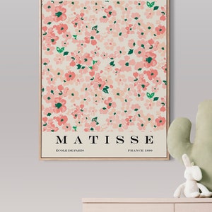 May include: A framed print of a floral design with pink flowers and green leaves. The print is titled "PAPIERS DECOUPES" and features the name "MATISSE" with the text "ECOLE DE PARIS" and "FRANCE 1890".