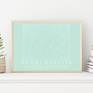 May include: A framed print of a line drawing of dancers in a circle, on a light blue background. The print is titled "Henri Matisse" and includes the text "Circle of Dancers 1910 Salon d'Automne Grand Palais des Champs-Elysees, Paris".