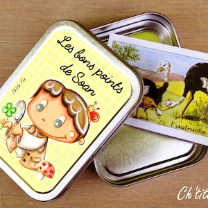May include: A yellow metal tin with a cartoon illustration of a person holding a magnifying glass. The tin has the text "Les bons points de Soan" on it. The tin is open and a card with an illustration of an ostrich is inside.