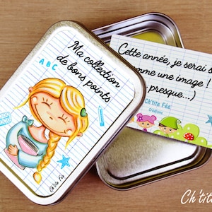 May include: A silver metal tin with a colorful illustration of a girl with blonde hair and a blue shirt. The tin has a white background with blue lines and the text "Ma collection de bons points" and "ABC". The tin is open and a white card with blue lines and the text "Cette année, je serai sage comme une image! presque...)" and "Ch'tite Fée Creations" is inside.