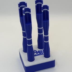 May include: A blue and white croquet set with five mallets. The mallets are blue with white stripes and a white top. The base is white with a blue border. The text "MALT" is visible on the base.