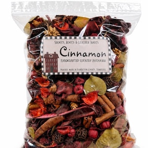 May include: A clear plastic bag filled with cinnamon-scented potpourri containing dried leaves, pinecones, and cinnamon sticks. The label reads: SHOOTS, ROOTS & LEATHER BOOTS, Cinnamon, HANDCRAFTED COUNTRY POTPOURRI, PROUDLY MADE IN ROBERTSON COUNTY, TENNESSEE.