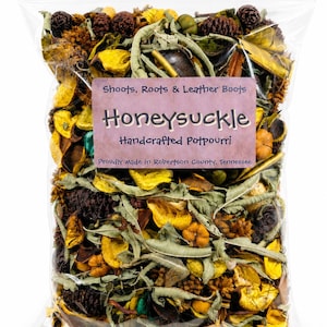 May include: A clear plastic bag filled with a mix of dried potpourri. The potpourri includes yellow, brown, and green dried leaves, flowers, and pine cones. A label reads "Shoots, Roots & Leather Boots Honeysuckle Handcrafted Potpourri."