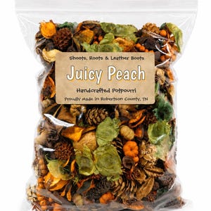 May include: A clear plastic bag filled with dried potpourri containing orange, green, and brown botanical elements, including pinecones and small pumpkins. A tan label reads: Shoots, Roots & Leather Boots, Juicy Peach, Handcrafted Potpourri, Proudly Made in Robertson County, TN.