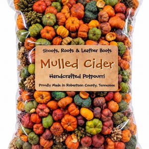 May include: A clear plastic bag filled with miniature decorative pumpkins and dried botanical elements. A tan label on the front reads: Shoots, Roots & Leather Boots, Mulled Cider, Handcrafted Potpourri, Proudly Made in Robertson County, Tennessee.