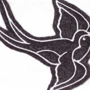 May include: Black embroidered swallow design with white stitching.