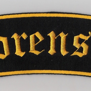 May include: Black fabric patch with a yellow embroidered border and the word "Sorensen" in a stylized font.