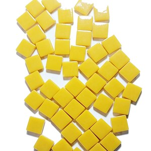 May include: A collection of butterscotch-colored, square mosaic tiles, each measuring 12mm. The tiles are arranged on a white background, with the text "Butterscotch 12mm" at the top. The tiles have a glossy finish.
