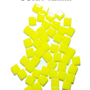 May include: Bright yellow square tiles scattered on a white background. The tiles are approximately 12mm in size, with the word "CORN" above them. The tiles have a glossy finish and are evenly colored.