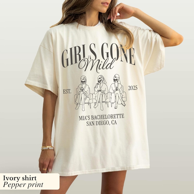 May include: Ivory-colored t-shirt with the text "GIRLS GONE Mild" and a graphic of three women. The shirt also includes "EST. 2025" and "MIA'S BACHELORETTE SAN DIEGO, CA".