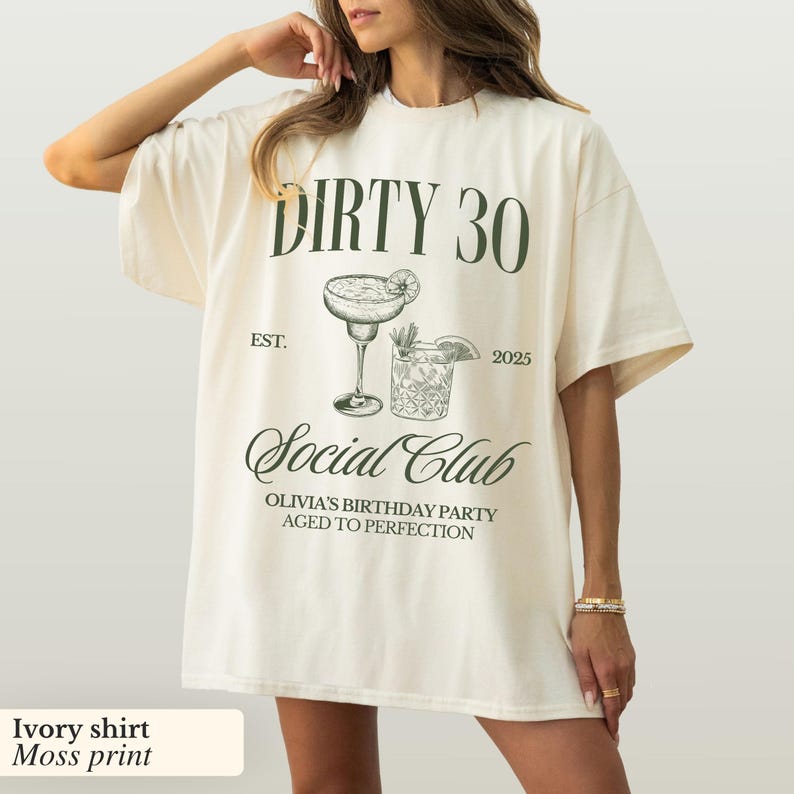 May include: Ivory t-shirt with a moss green print that says "Dirty 30 Est. 2025 Social Club Olivia's Birthday Party Aged to Perfection". The print also includes a drawing of two cocktails.