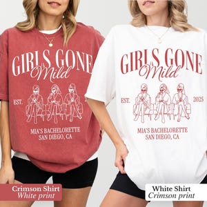 May include: Two oversized t-shirts, one crimson and one white, each with a graphic that reads "GIRLS GONE Mild" above an illustration of three figures. Below the illustration is "MIA'S BACHELORETTE SAN DIEGO, CA".