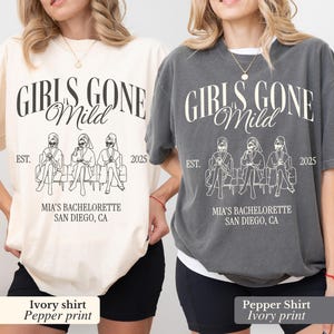 May include: Two t-shirts, one ivory and one pepper, with the text "GIRLS GONE Mild" in a script font. Below the text is a line drawing of three figures seated on a bench. The text "MIA'S BACHELORETTE SAN DIEGO, CA" is below the drawing.