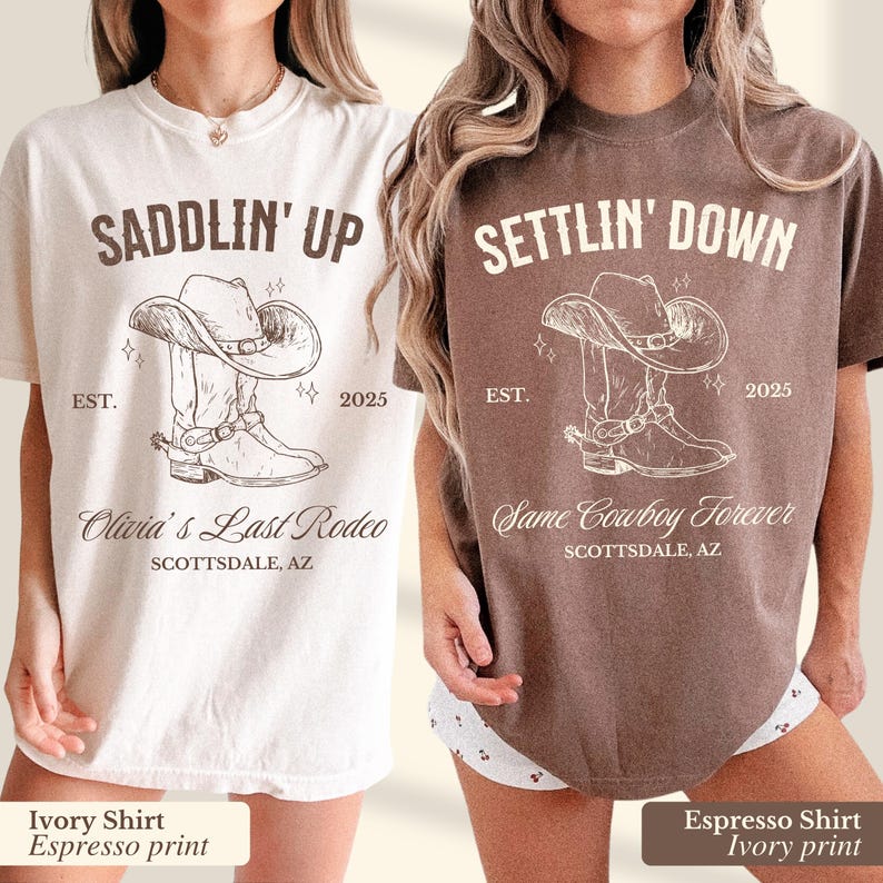 May include: Two t-shirts with a cowboy boot graphic and text. The first shirt is ivory with brown text and the second shirt is brown with ivory text. The text on the first shirt reads "Saddlin' Up" and "Olivia's Last Rodeo". The text on the second shirt reads "Settlin' Down" and "Same Cowboy Forever".