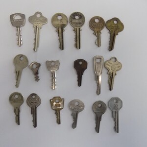 May include: A collection of 18 vintage keys, some with visible brand names like "Yale" and "Kwikset". The keys are silver and have various shapes and sizes.