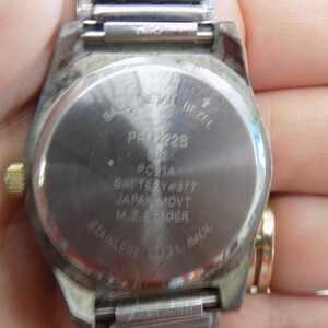 Pu&ograve; includere: Il retro di un orologio argentato con un cinturino in acciaio inossidabile. Il quadrante dell'orologio ha il testo "BASE MEMA BEZEL PR228 2 PC21A BATTERY #377 JAPAN MOVT M.ZEROER STAINLESS STEEL BACK".