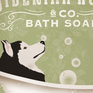 K&ouml;nnte beinhalten: Ein schwarz-wei&szlig;er Husky-Hund befindet sich in einer wei&szlig;en Badewanne mit gr&uuml;nem und wei&szlig;em Blumenhintergrund. Der Hund schaut zu den Blasen, die in der Luft schweben. Der Text auf dem Bild lautet "Delightful & Co. Bath Soap".