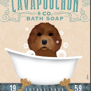 Op de afbeelding: Een bruine Cavapoochon-hond zit in een wit bad met bubbels. De tekst boven de hond luidt "Cavapoochon & Co. Bath Soap" en onder het bad staat "Gevestigd 19 59 Was je poten".