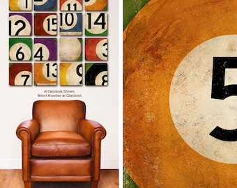 May include: A set of 16 vintage-style billiard ball canvases, each featuring a different number from 1 to 15 and the 8 ball. The canvases are arranged in a grid pattern and have a distressed, aged look. The text "16 Canvases Shown Select Number at Checkout" is printed below the grid.
