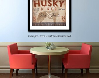 Peut inclure: Une enseigne de style vintage de diner avec le texte "Husky Diner" et "Fine Foods" dans un schéma de couleurs brun et rouge. L'enseigne présente une silhouette de chien husky avec le texte "If it has four legs & it begs, eat!" et "No paws on the table." L'enseigne est encadrée en noir.