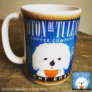 Puede incluir: Taza de caf&eacute; de cer&aacute;mica blanca con una ilustraci&oacute;n de perro Coton de Tulear y el texto "COTON DE TULEAR COFFEE COMPANY". La taza tiene un asa blanca y un gr&aacute;fico de taza de caf&eacute; naranja. Tambi&eacute;n son visibles las palabras "LIGHT ROAST".