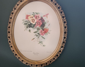 Pode incluir: Uma moldura oval dourada com uma impressão floral de flores rosa e brancas com folhas verdes. A impressão é intitulada "Fairy Ladies" por Rex & Lang.