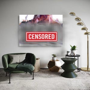 May include: A modern living room with a large abstract artwork on the wall. The artwork has a red "CENSORED" stamp over it. A green armchair, side tables, and a floor lamp complete the decor.