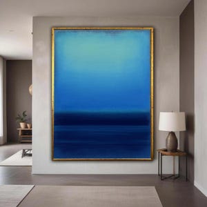 Puede incluir: Gran pintura abstracta con un degradado de azules, desde turquesa claro en la parte superior hasta azul marino oscuro en la inferior. La obra está enmarcada en un borde dorado, creando un contraste llamativo. La pieza se exhibe en un entorno interior moderno.