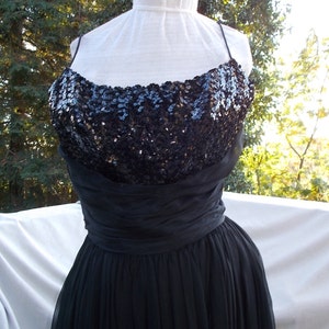 May include: A black sequined bodice and chiffon skirt evening gown. The bodice is made of black sequins and the skirt is made of black chiffon.