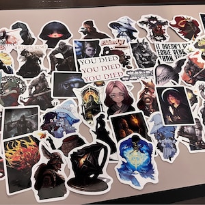 Könnte beinhalten: Eine Sammlung von Aufklebern zum Thema des Videospiels Elden Ring. Die Aufkleber zeigen verschiedene Charaktere, Kreaturen und Symbole aus dem Spiel. Einige der Aufkleber haben Text, darunter "Elden Ring", "EldenAid" und "You Died".