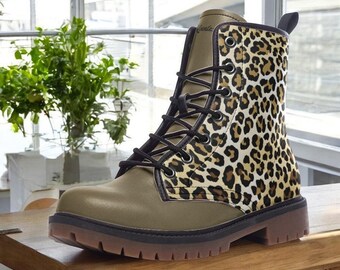 May include: An olive green and leopard print combat boot with black laces. The boot features a brown sole and a pull tab at the back. The leopard print is a mix of tan and brown spots.