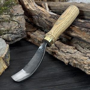May include: A curved carving knife with a wooden handle and a brass ferrule. The blade is made of steel and has a curved shape. The knife is designed for woodworking and carving.