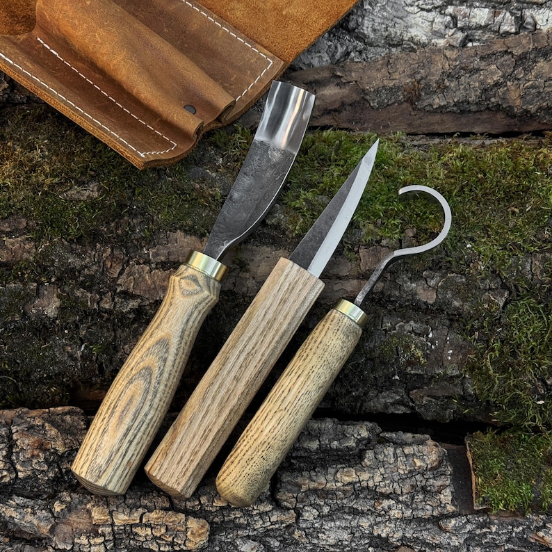 Spoon carving knife set on bark, forged carving tools with ash wood handles.