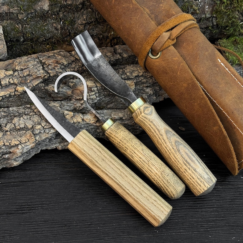 Wood carving tools beside leather roll case, spoon carving kit for bowl hollowing and detail work.