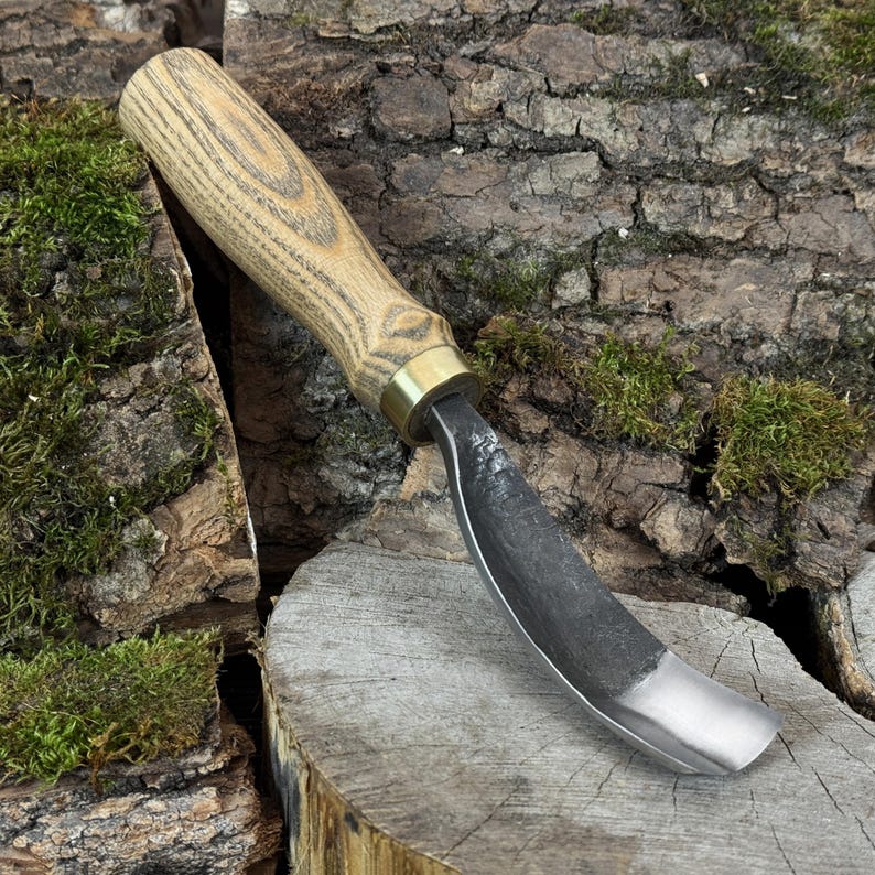 Compact spoon gouge resting on mossy bark, short curved blade for tight-radius hollowing in cups, ladles and small bowls.