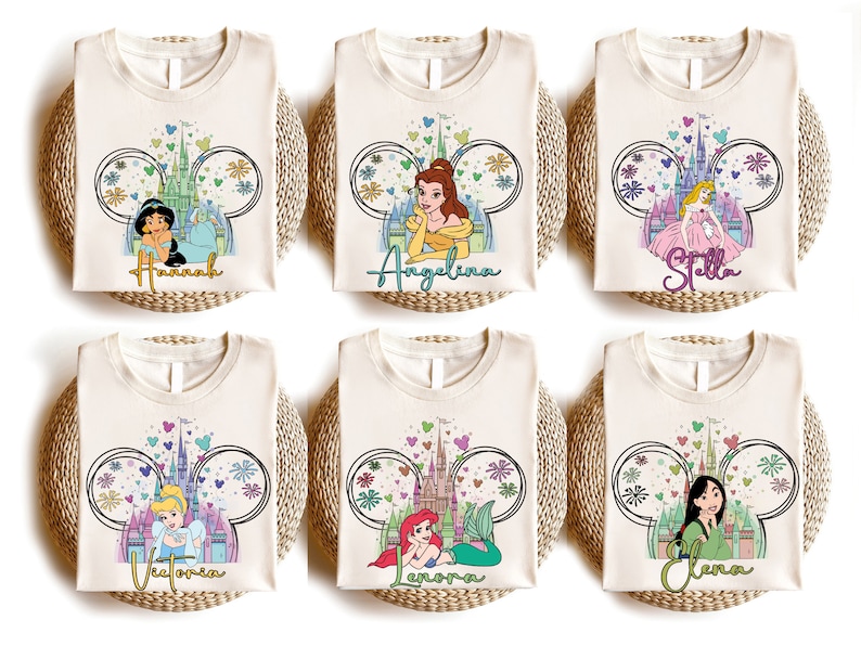 K&ouml;nnte beinhalten: Sechs wei&szlig;e T-Shirts mit einer Disney-Prinzessin und dem Text "Hannah", "Angelina", "Stella", "Victoria", "Aurora" und "Elena" bedruckt.