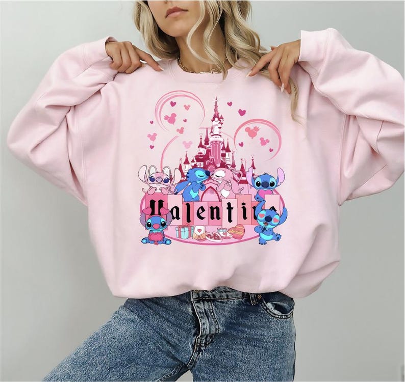 a woman wearing a pink sweatshirt with a castle on it
