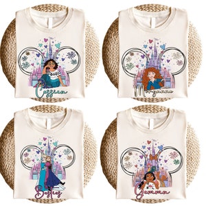 K&ouml;nnte beinhalten: Vier wei&szlig;e T-Shirts mit einem Mickey-Maus-Ohren-Design, das ein Disney-Schloss und eine Prinzessin zeigt. Jedes Shirt hat eine andere Prinzessin und einen Namen, der unter dem Design gedruckt ist. Die Namen sind: Cessia, Morganna, Bastiez und Gemma.