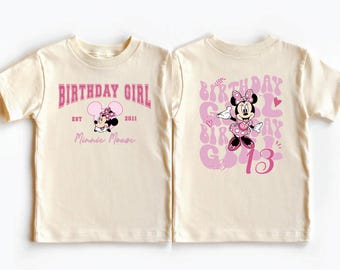 Puede incluir: Una camiseta de color crema con un gráfico de Minnie Mouse. La parte delantera muestra el texto "BIRTHDAY GIRL" con "EST 2011" y "Minnie Mouse". La parte trasera presenta una gran ilustración de Minnie Mouse, el texto "BIRTHDAY GIRL" y "13".