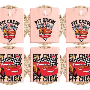 Puede incluir: Seis camisetas rosas con un dise&ntilde;o tem&aacute;tico de Cars. Las camisetas presentan a Rayo McQueen, el n&uacute;mero 4 y el texto "Pit Crew". Las camisetas est&aacute;n etiquetadas con las palabras "Hermana", "T&iacute;o", "Hermano" y "Pit Crew" repetidas varias veces.