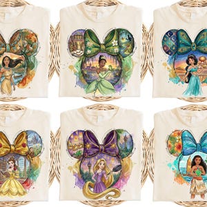 May include: Six cream-coloured t-shirts featuring Disney princess designs within Mickey Mouse ear silhouettes. Each shirt showcases a different princess, with vibrant watercolour illustrations and detailed backgrounds.