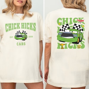 Könnte beinhalten: Ein weißes T-Shirt mit einem grünen Aufdruck eines Rennwagens mit dem Text "Chick Hicks" und "Cars" auf der Vorderseite. Die Rückseite des Shirts zeigt einen grünen Aufdruck desselben Rennwagens mit dem Text "Chick Hicks" und "Cars" in einer Retro-Schrift.